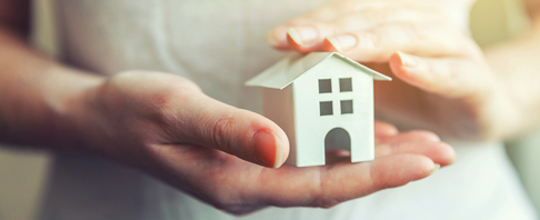 Mortgages hands holding a model house